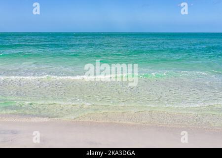 Horizon at Gulf of Mexico beach in Naples, Southwest Florida with beautiful turquoise clear blue green ocean sea water and waves on shroe Stock Photo