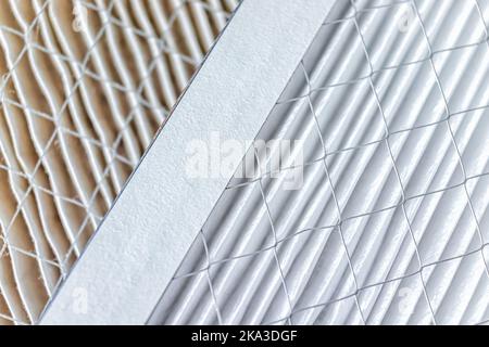Macro closeup of side by side comparison of dirty and clean AC air conditioner filters for home house use with metal wire and paper filtration system Stock Photo