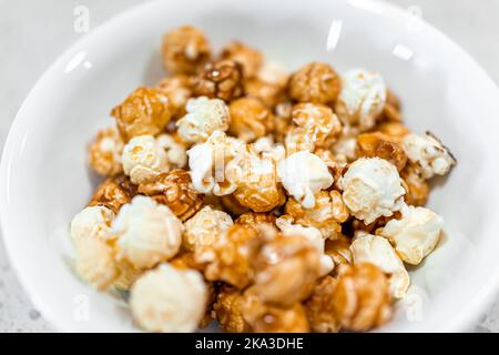 Macro closeup of cheese caramel caramelized popcorn snack sweet treat dessert food in plate bowl isolated against white background