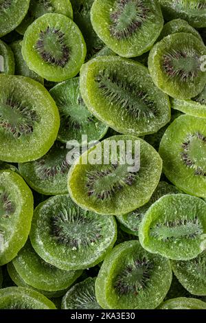Full frame top view of pile of sliced sweet green dry kiwi with sugar placed on surface Stock Photo