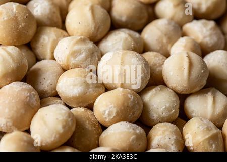 Full frame top view of scattered Macadamia Nuts in sugar powder placed on table Stock Photo
