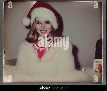 A beautiful young woman dressed for Christmas, retro vintage Polaroid Stock Photo