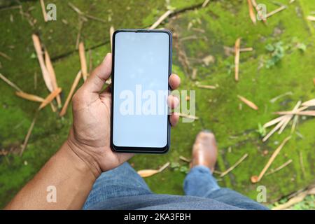rear view of young man using smart phone at outdoor  Stock Photo
