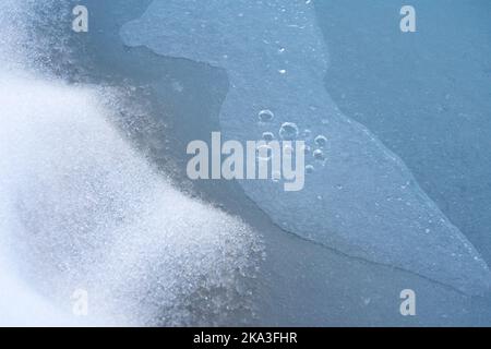 Abstract background of bubbles of air under layer of thin ice in clear water Stock Photo