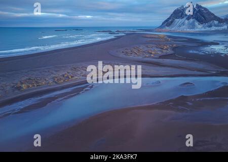 Drone view of river estuary located on shore of blue sea against cloudy sky in evening in Iceland Stock Photo