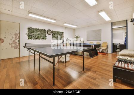 Comfortable play room with pool table and table tennis located in lounge area of coworking space Stock Photo