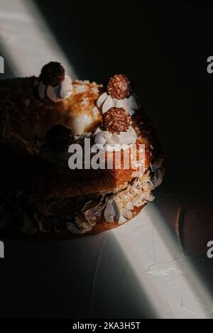 Roscon of Kings with sprinkles decorated with chocolate balls placed on table with shadows Stock Photo