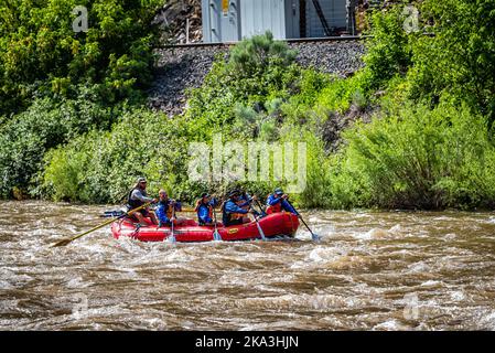 Glenwood Springs, USA - June 29, 2019: Group of candid people on boat in Colorado's Roaring Fork River white water rafting in summer season Stock Photo