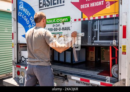 Ft Myers, USA - May 16, 2022: Man male person locking closing door of U-haul cargo truck trailer vehicle for move, moving relocation from Florida by l Stock Photo