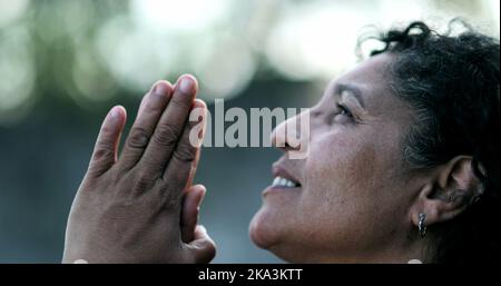 Evangelical Brazilian woman praying to God. Spiritual mature person praising God Stock Photo