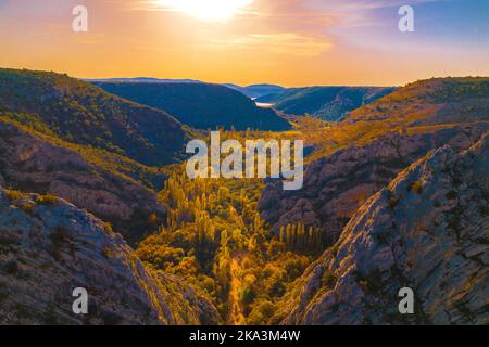 The aerial panoramic view on the sunset in the mountains in Croatia. Canyon in Krka national park in Croatia. Golden autumn in nature. Stock Photo