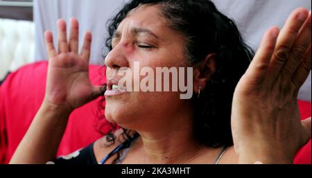 Evangelical Brazilian woman praying to God. Spiritual mature person praising God Stock Photo