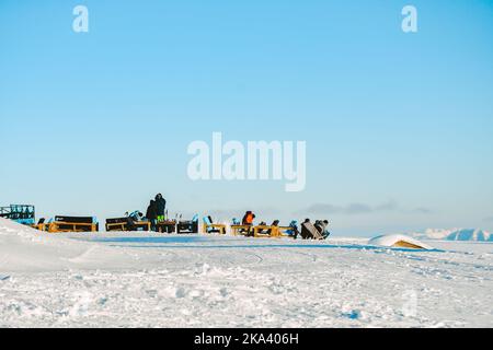 Skiers sit chill outside in Gudauri ski resort restaurant on ski break after ride on georgian caucasus holiday vacation Stock Photo