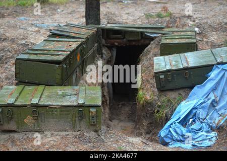 KHARKIV REGION, UKRAINE - OCTOBER 26, 2022 - Ammunition boxes line the stairs leading into a dugout in a forest near Izium after the liberation of the Stock Photo