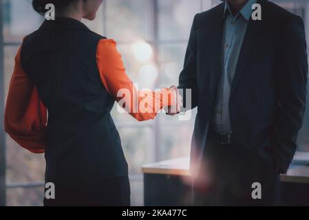 Business people shaking hands together, greeting and well come, happy positive colleagues in work space, smiling business team talking having fun enjo Stock Photo