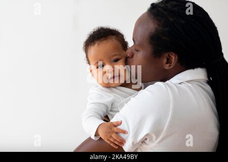 Loving Young Black Dad Holding And Kissing His Adorable Baby Son, Closeup Stock Photo