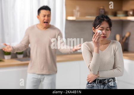 Angry asian husband and wife having fight at kitchen Stock Photo