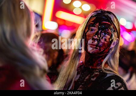 Essen, Germany. 31st Oct, 2022. A woman with fake blood takes part in the Zombiewalk on Halloween in NRW, in Essen hundreds of dressed up people parade through the city center in the afternoon as part of a Halloween parade with Zombiewalk. Credit: Christoph Reichwein/dpa/Alamy Live News Stock Photo