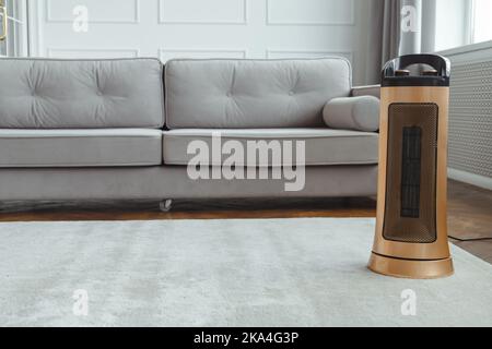 Modern upright floor electric fan heater on floor in living room at home. Space for text Stock Photo