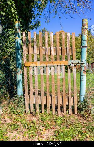 old simple wooden garden gate at the entrance to a small garden Stock Photo