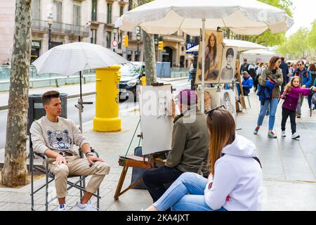 BARCELONA, SPAIN - April 10, 2022: street artist painting a caricature on the Rambla in Barcelona (Spain), vacation concept, selective approach. Stock Photo