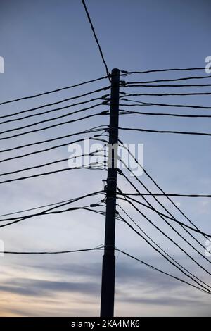 Electrical wires on pole. Many wires against sky. High voltage pole. Stock Photo