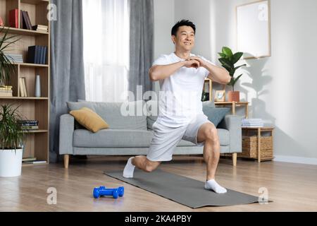 Athletic asian man training alone at home Stock Photo