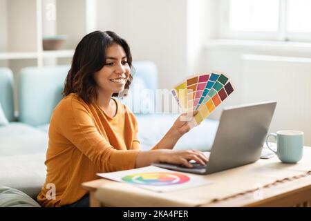 Arab Female Freelance Graphic Designer Working With Laptop And Color Swatches Stock Photo