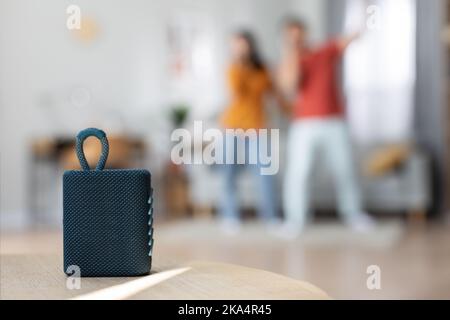 Selective focus on brand new portable speaker over singing couple Stock Photo