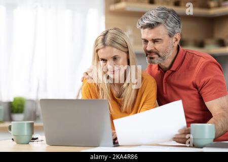 Attractive middle aged spouses working from home Stock Photo