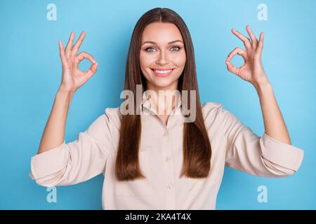 Photo of gorgeous optimistic satisfied girl straight hairdo dressed beige blouse showing okey feedback isolated on blue color background Stock Photo