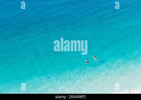 Beautiful crystal clear sea water with a couple enjoying a swim Stock Photo