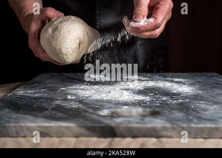 Man preparing pizza, dough on marble table. Stock Photo