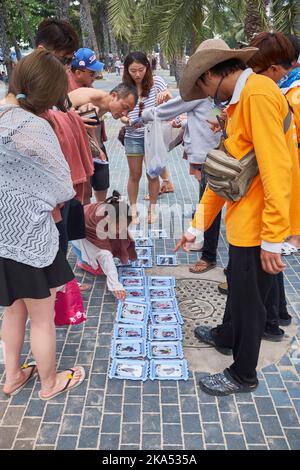 Tourists choose souvenir photos after returning from boat trip in Pattaya Thailand Stock Photo