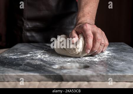 Man preparing pizza, dough on marble table. Stock Photo
