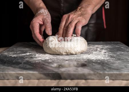 Man preparing pizza, dough on marble table. Stock Photo