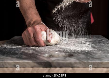 Man preparing pizza, dough on marble table. Stock Photo