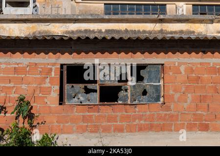 The broken windows of a derelict factory building. Stock Photo