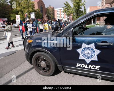 A University Police Services vehicle, and law enforcement officer, watches as dozens of protesters march from the University of Nevada, Reno to downtown decrying the Iranian government and the death of Masha Amini. Starting at the University of Nevada, hundreds of Reno's more than 2,000 Iranian Americans marched through downtown Reno calling for the end of what they said was Iranís oppressive, religious regime.Masha Amini was a central figure in the demonstrations. Amini was abducted by Iran's morality police and allegedly was murdered while in the custody of the Iranian government. Stock Photo