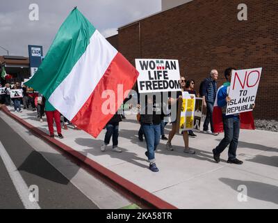 Protesters carry an Iranian flag and placards that says, 'Woman, Life, Freedom' and No to Islamic Republic' during a demonstration march decrying the Iranian government and the death of Masha Amini. Starting at the University of Nevada, hundreds of Reno's more than 2,000 Iranian Americans marched through downtown Reno calling for the end of what they said was Iranís oppressive, religious regime.Masha Amini was a central figure in the demonstrations. Amini was abducted by Iran's morality police and allegedly was murdered while in the custody of the Iranian government. Stock Photo