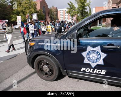 Reno, Nevada, USA. 22nd Oct, 2022. A University Police Services vehicle, and law enforcement officer, watches as dozens of protesters march from the University of Nevada, Reno to downtown decrying the Iranian government and the death of Masha Amini. Starting at the University of Nevada, hundreds of Reno's more than 2,000 Iranian Americans marched through downtown Reno calling for the end of what they said was IranÃ-s oppressive, religious regime.Masha Amini was a central figure in the demonstrations. Amini was abducted by Iran's morality police and allegedly was murdered while in Stock Photo