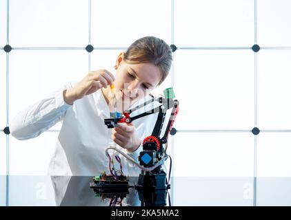 Young woman student assembling electronic devices in the robotics laboratory Stock Photo