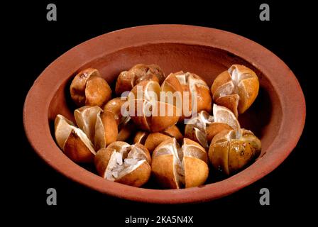 lime pickles in a clay pot, lime preserving process with salt, closeup, Sri Lankan home made lime pickle, isolated on black (Lunu Dehi) Stock Photo