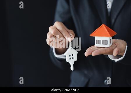 House models and coin in human hands, Mortgage concept by money house from the coins. Stock Photo