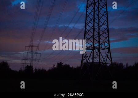 Landesbergen, Germany. 01st Nov, 2022. Electricity pylons stand on a road before sunrise. Chancellor Scholz has announced forthcoming key points to ease the burden on citizens and companies in the energy crisis. Credit: Lino Mirgeler/dpa/Alamy Live News Stock Photo