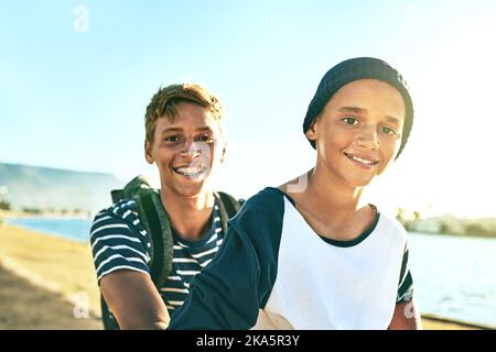 We love being out here. Cropped portrait of a young boy giving his younger brother a lift on a bicycle outside. Stock Photo