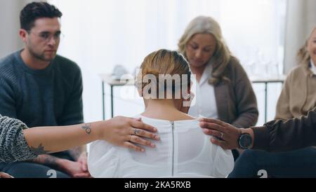 Group therapy, meeting and counseling with people in support to console a woman patient during a session for health. Community, mental health and Stock Photo