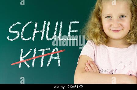 Pupil in front of a blackboard with the German words: Schule statt Kita (school instead of daycare) Stock Photo