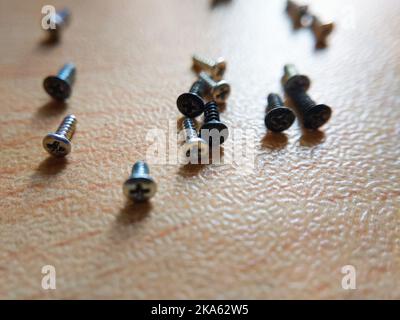 Small Cross Recessed Flat Head Machine Screws on a table top. India. Selective focus Stock Photo