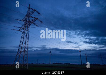 Landesbergen, Germany. 01st Nov, 2022. An electricity pylon is seen against dark clouds before sunrise. Chancellor Scholz has announced forthcoming key points to ease the burden on citizens and companies in the energy crisis. Credit: Lino Mirgeler/dpa/Alamy Live News Stock Photo